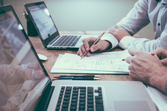 2 people working with planning document and laptops