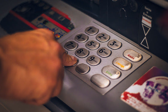 At a banking ATM, person's finger pushing machine buttons