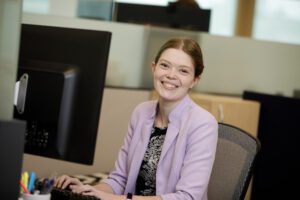JCCS staff member smiling at her desk