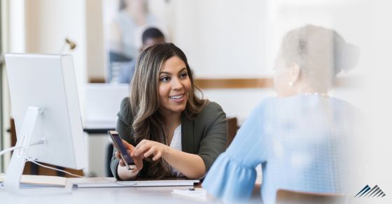 A woman shows a client retirement information on her phone