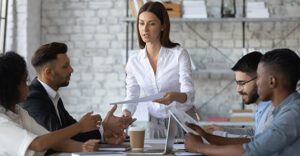 An employee distributes papers to her coworkers