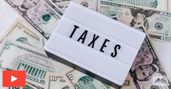 A pile of money with "taxes" on top