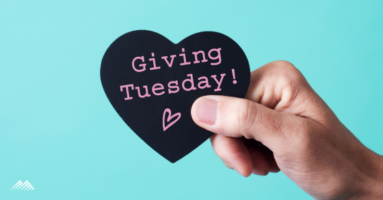 A hand holding a heart that says 'giving Tuesday'