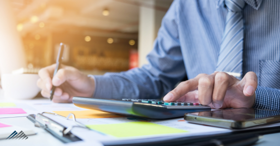 A businessman types on a calculator