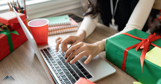 Christmas gifts surround a computer