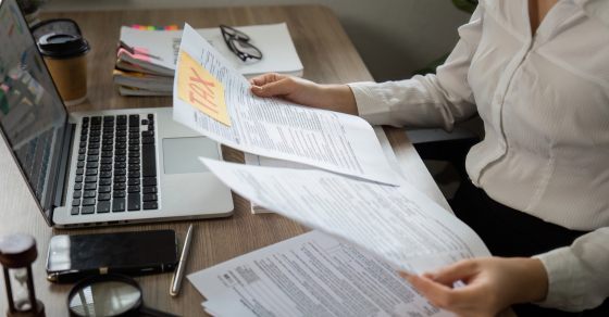 Someone filing their taxes at their kitchen table