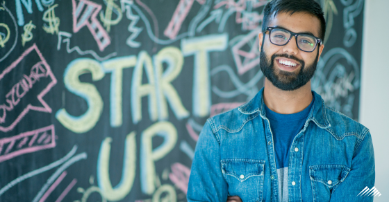 A man standing in front a chalkboard that says "start up"