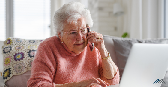 A discouraged senior woman on the phone and in front of her computer.