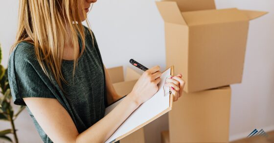 A woman with a clipboard and moving boxes
