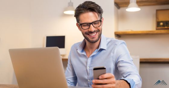 A man with a computer and phone at desk