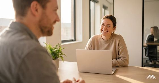Two smiling people at a desk